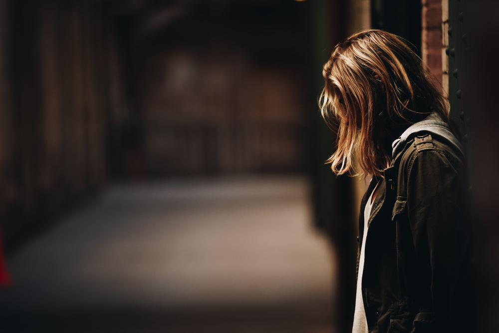 female-leaning-against-wall-looking-down-hallway-with-blurred-background-alcatraz-island