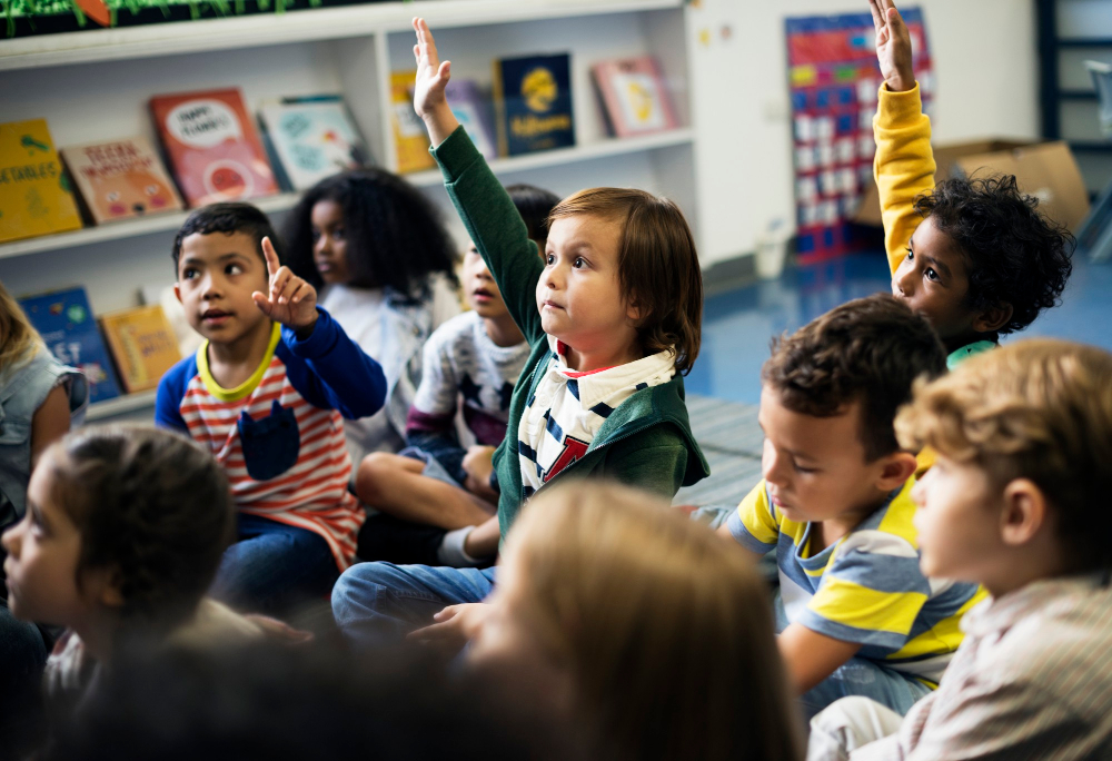 Boy raising his hand in class Boy raising his hand in class